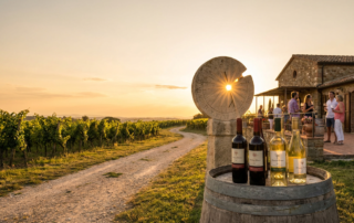 bottles of summer solstice wine on a barrel with vineyard sunset and stone sundial.